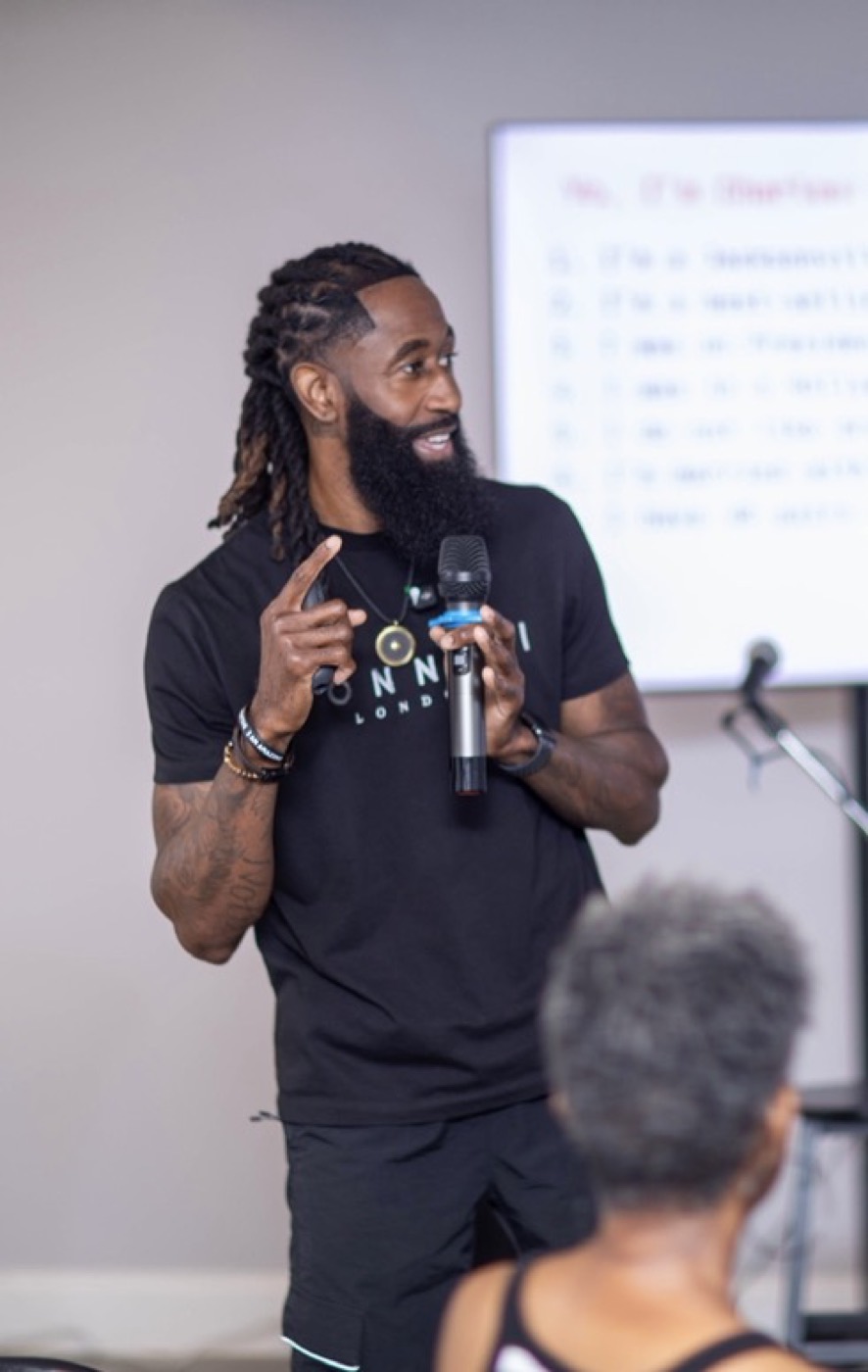 Charles speaking with a microphone to a leadership audience