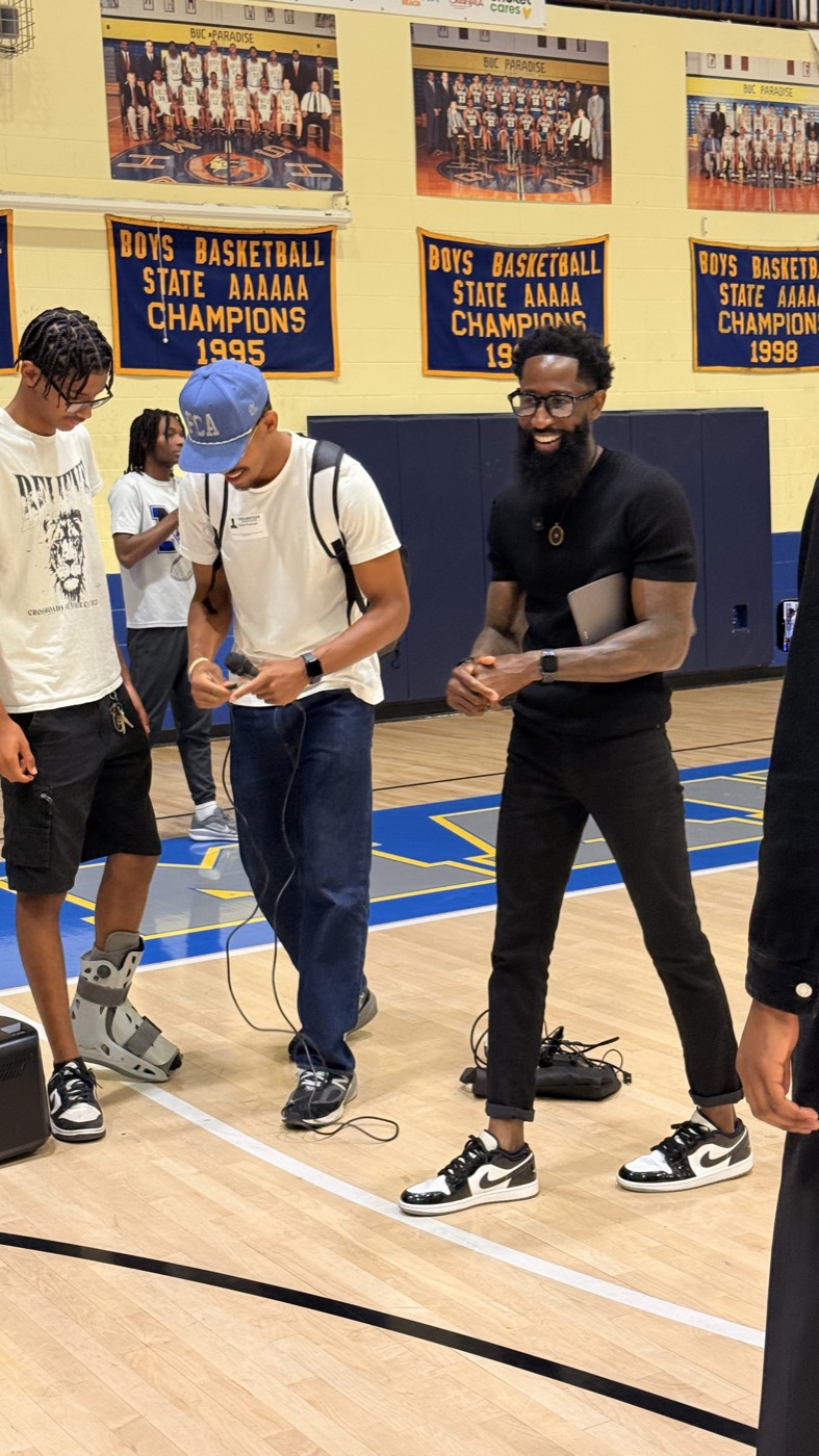 Charles speaking to students in a high school gym